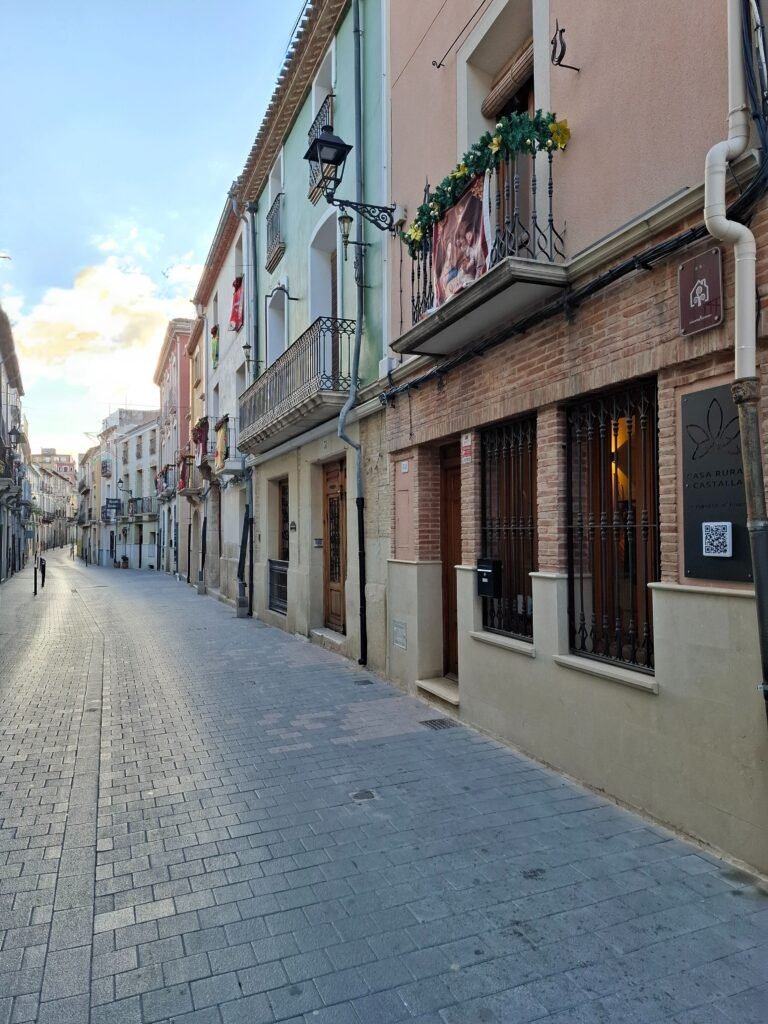 The front of Casa Rural Castalla on Carrer Major, with its planted balcony and the old town beyond