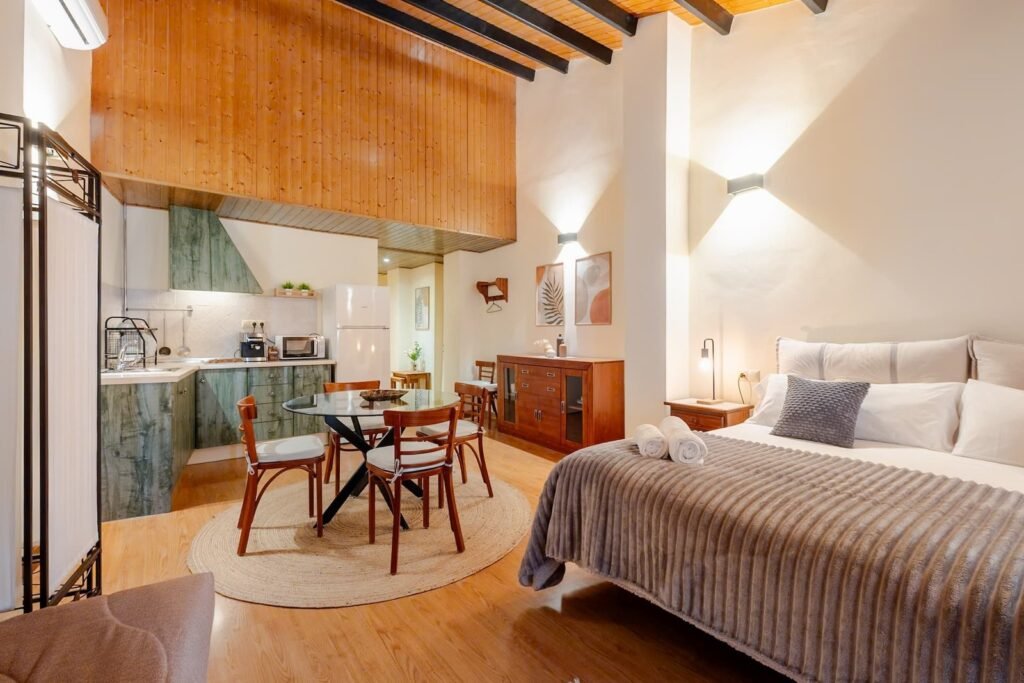 The apartment seen as a whole, with its kitchenette, dining table and double bed