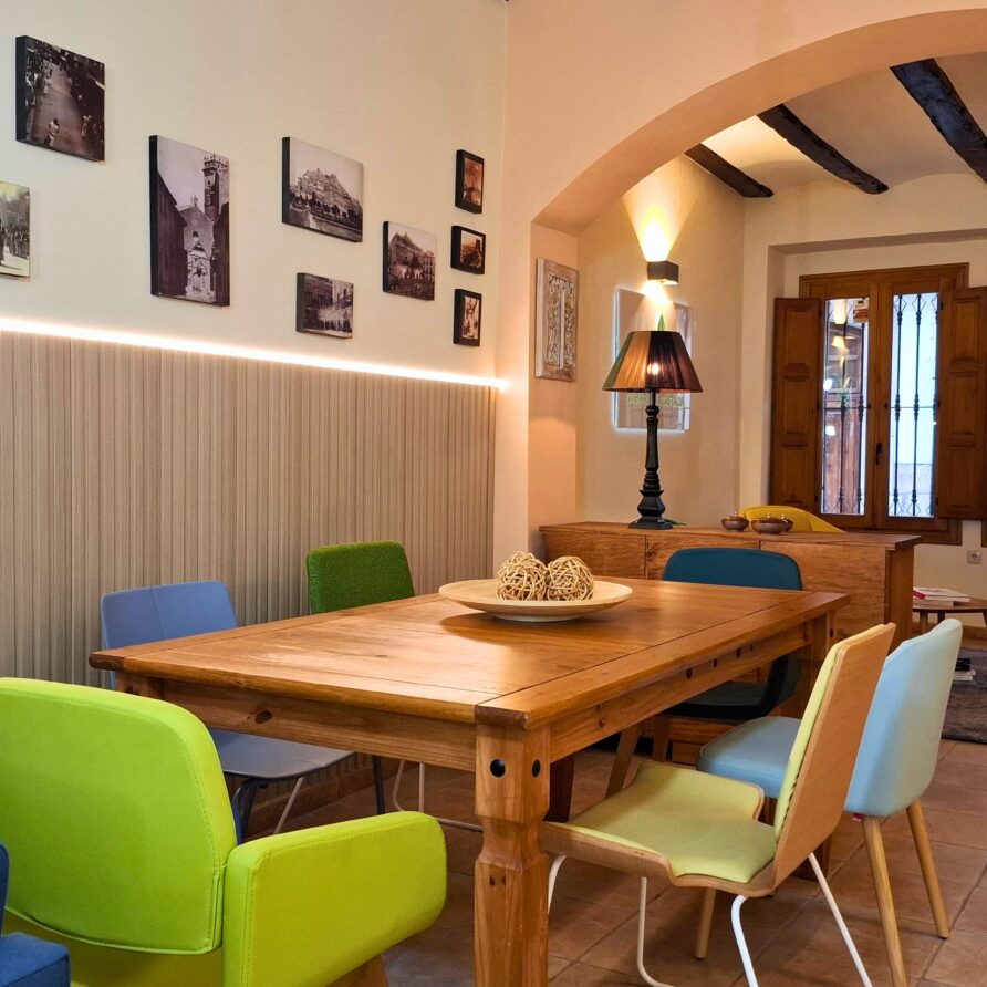 a table with colorful chairs in a room en el hotel en castalla - casa rural castalla
