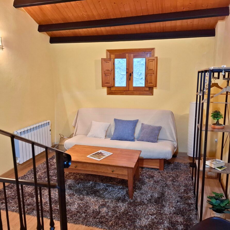 Salón de estar abuhardillado con sofá cama doble en Casa Rural Castalla