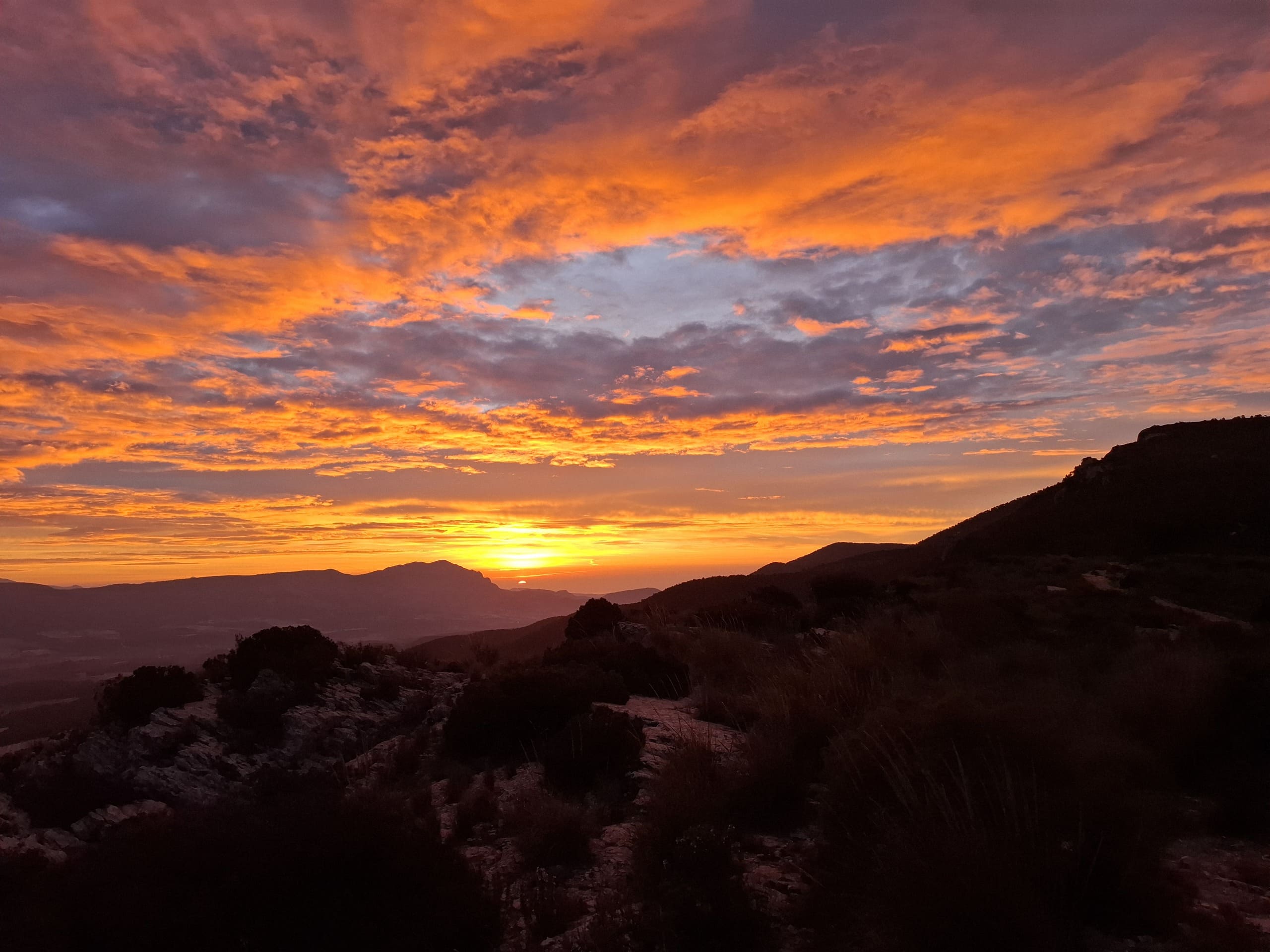 Amanecer en las montañas de Castalla con cielo anaranjado, ideal para rutas de senderismo en la naturaleza al amanecer