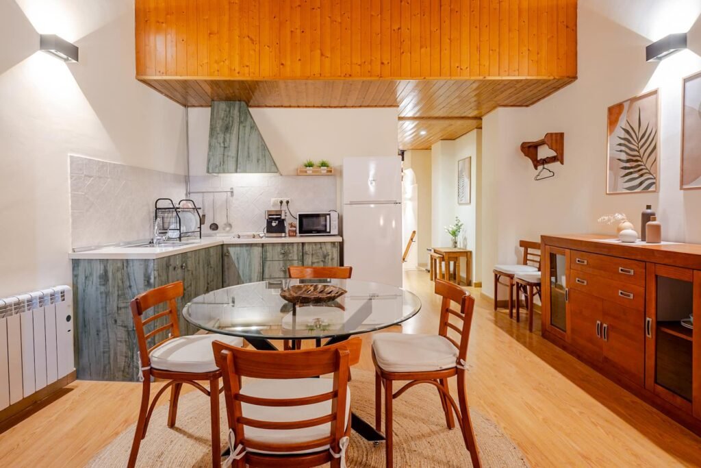 Cocina y mesa de comedor del apartamento de Casa Rural Castalla, con muebles en verde y nevera