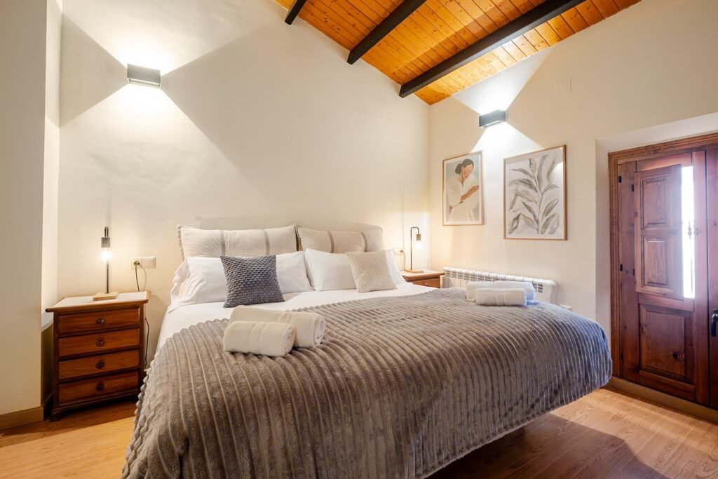 Cama de matrimonio del apartamento de Casa Rural Castalla bajo el techo de madera a dos aguas