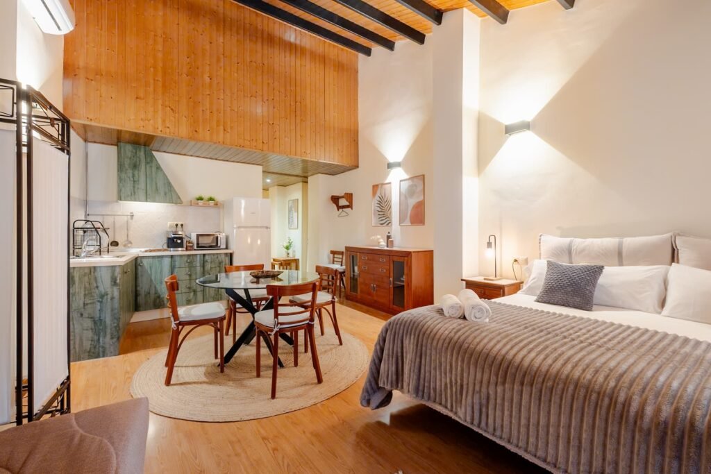 Apartamento de Casa Rural Castalla con su cocina propia, la mesa de comedor y el biombo que separa la cama