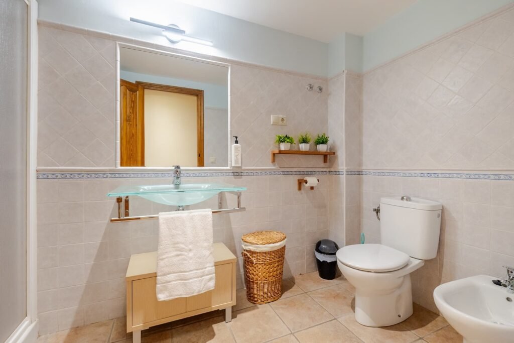 Baño completo de Casa Rural Castalla con ducha, lavabo de cristal y toallero