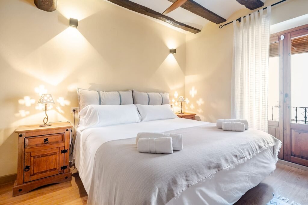 Cama de matrimonio de la habitación principal de Casa Rural Castalla con salida al balcón